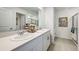 Bathroom with double vanity featuring white cabinets, quartz countertop, framed mirror and decorative accents at 5133 Forget Me Not Ave, Lake Hamilton, FL 33851