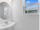 Close-up of a bathroom sink and vanity area featuring a modern round mirror at 5133 Forget Me Not Ave, Lake Hamilton, FL 33851