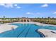 Resort-style community pool with ample seating, shaded pavilion, and palm trees, perfect for relaxation and recreation at 5133 Forget Me Not Ave, Lake Hamilton, FL 33851