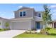 Exterior of two-story home with a two-car garage, blue door, and landscaping at 5133 Forget Me Not Ave, Lake Hamilton, FL 33851