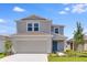 Charming two-story home showcasing a neutral color palette, well-manicured lawn, and an attached two-car garage at 5133 Forget Me Not Ave, Lake Hamilton, FL 33851
