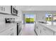 White kitchen with stainless appliances and a large window, offering a seamless transition to the outdoor space at 5133 Forget Me Not Ave, Lake Hamilton, FL 33851