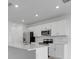 White kitchen with stainless appliances, a large island, and ample counter space, illuminated by recessed lighting at 5133 Forget Me Not Ave, Lake Hamilton, FL 33851