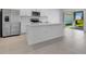 Bright kitchen featuring stainless steel appliances, an island with a sink, and sliding glass doors leading to outdoor space at 5133 Forget Me Not Ave, Lake Hamilton, FL 33851