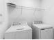 Bright laundry room with a wire shelf above the new white washer and dryer at 5133 Forget Me Not Ave, Lake Hamilton, FL 33851