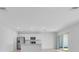 Bright living room showcasing an open layout with stainless steel appliances and sliding glass door access to the yard at 5133 Forget Me Not Ave, Lake Hamilton, FL 33851