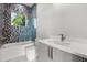 Modern bathroom with stylish blue tile accent wall, glass shower door, and sleek vanity at 1521 Chestnut Ave, Winter Park, FL 32789