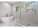 Sleek bathroom with a frameless glass shower, soaking tub, neutral tiling, and a niche for storage at 1521 Chestnut Ave, Winter Park, FL 32789