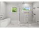 Modern bathroom with glass-enclosed shower, soaking tub, and natural light streaming through the windows at 1521 Chestnut Ave, Winter Park, FL 32789