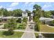 Stunning modern home featuring lush landscaping, mature trees, and a paved driveway at 1521 Chestnut Ave, Winter Park, FL 32789
