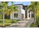 Modern two-story home with meticulously landscaped front yard and paver driveway, surrounded by mature palm trees at 1521 Chestnut Ave, Winter Park, FL 32789