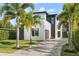 Contemporary two-story home boasting a beautifully landscaped front yard and a long driveway lined with palm trees at 1521 Chestnut Ave, Winter Park, FL 32789