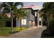 Charming two-story home with landscaped front yard, paver driveway, and modern architectural details at sunset at 1521 Chestnut Ave, Winter Park, FL 32789