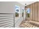 Hallway with modern railing, wood floors, contemporary lighting fixture, and natural light from surrounding windows at 1521 Chestnut Ave, Winter Park, FL 32789