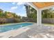 Inviting pool area featuring a pristine pool, lush landscaping, a black fence and cozy hammock for relaxation at 1521 Chestnut Ave, Winter Park, FL 32789