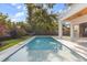 Sparkling pool in a private backyard, complemented by lush landscaping, a black fence, and outdoor living space at 1521 Chestnut Ave, Winter Park, FL 32789