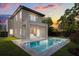 Modern home featuring a private pool, covered patio, second story balcony and lush backyard at sunset at 1521 Chestnut Ave, Winter Park, FL 32789