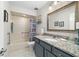 Bathroom features a tub with shower, granite countertop vanity, and framed mirror at 2049 Se 37Th Court Cir, Ocala, FL 34471