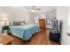 Bright bedroom features hardwood floors, ceiling fan, and calming blue color scheme at 2049 Se 37Th Court Cir, Ocala, FL 34471