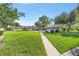 Community pool area with lush green lawn, gazebo, and inviting walkway at 2049 Se 37Th Court Cir, Ocala, FL 34471
