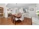 Open-concept dining room with a wood table, elegant chandelier, and views into the stylishly appointed kitchen at 2049 Se 37Th Court Cir, Ocala, FL 34471