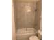 Compact bathroom features neutral tiled walls, a bathtub with shower, and essential fixtures at 5127 Eaglesmere Dr # A02, Orlando, FL 32819