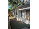 Side exterior view showing the entry door, storm door and some landscaping at 5429 Vanderlin St, Orlando, FL 32810
