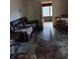 Living room view showing an older couch, tables and doorway at 5429 Vanderlin St, Orlando, FL 32810