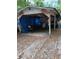 Dilapidated exterior shed covered in blue tarps and debris at 5429 Vanderlin St, Orlando, FL 32810