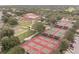Aerial view showcases community amenities: tennis courts, pickleball, and community center amid lush landscaping at 3905 Westerham Dr, Clermont, FL 34711