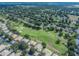 Expansive aerial view of a golf course community with lush green fairways and well-maintained homes at 3905 Westerham Dr, Clermont, FL 34711