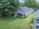 Aerial view of backyard featuring well-maintained grass, lush greenery, and a charming patio area at 3905 Westerham Dr, Clermont, FL 34711