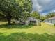 Sprawling backyard featuring well-maintained grass, lush greenery, and a charming patio area at 3905 Westerham Dr, Clermont, FL 34711