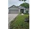 Charming single-story home featuring a two-car garage, brick driveway, and well-maintained landscaping at 3905 Westerham Dr, Clermont, FL 34711