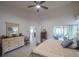 Spacious main bedroom with a ceiling fan, neutral walls, and view into screened porch and backyard at 3905 Westerham Dr, Clermont, FL 34711