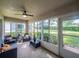 Cozy screened porch featuring comfortable seating, ceiling fan, and views of the lush backyard landscaping at 3905 Westerham Dr, Clermont, FL 34711