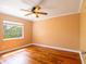 This cozy bedroom has hardwood floors, a ceiling fan, and a bright window at 4209 Forrestal Ave, Orlando, FL 32806