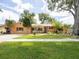 Charming single-story home featuring a lush green lawn, mature trees, and welcoming front entrance at 4209 Forrestal Ave, Orlando, FL 32806