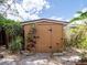 Exterior view of a small backyard storage shed surrounded by lush landscaping at 4209 Forrestal Ave, Orlando, FL 32806