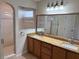 Bathroom featuring double sinks with granite countertops, and a glass door shower at 17430 Se 110Th Ter, Summerfield, FL 34491