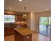 Well-lit kitchen features an island, wooden cabinets, and a sliding door to the patio at 17430 Se 110Th Ter, Summerfield, FL 34491