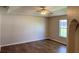 Bright living room featuring wood floors, a ceiling fan, and a window offering lots of natural light at 17430 Se 110Th Ter, Summerfield, FL 34491