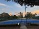 View of well-maintained tennis courts ready for play at dusk at 17430 Se 110Th Ter, Summerfield, FL 34491