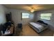 Bedroom with a desk for working, a ceiling fan for keeping cool, and warm natural lighting at 1818 Mango Tree Dr, Edgewater, FL 32132