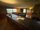 Large living room featuring a fireplace, a large sofa, and natural light from the large front windows at 1818 Mango Tree Dr, Edgewater, FL 32132