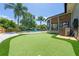 Backyard featuring a putting green, pool, and a screened-in porch, perfect for outdoor relaxation and entertainment at 219 Vermont Ave, St Cloud, FL 34769
