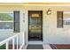 Close-up of the front door, accented by stylish shutters and a modern exterior light fixture at 219 Vermont Ave, St Cloud, FL 34769