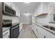 Bright kitchen showcases stainless appliances, granite countertops, subway tile, and woodgrain flooring at 219 Vermont Ave, St Cloud, FL 34769