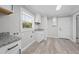 Bright laundry room boasts granite countertops, woodgrain floors, a window, and white cabinets at 219 Vermont Ave, St Cloud, FL 34769