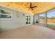 The sunroom features a wood ceiling with fan, big windows, and view to the putting green at 219 Vermont Ave, St Cloud, FL 34769